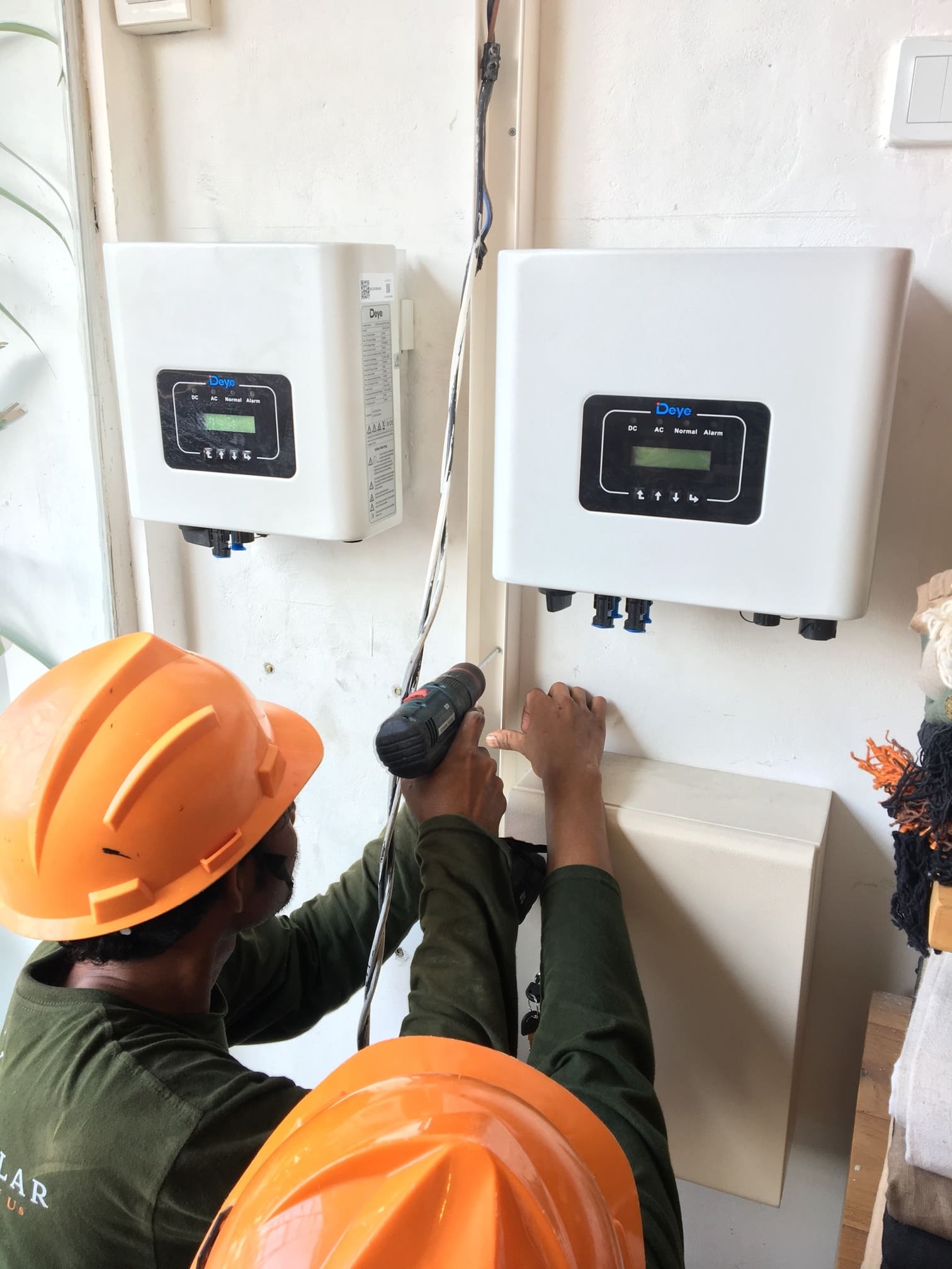 Technician installing a solar power inverter
