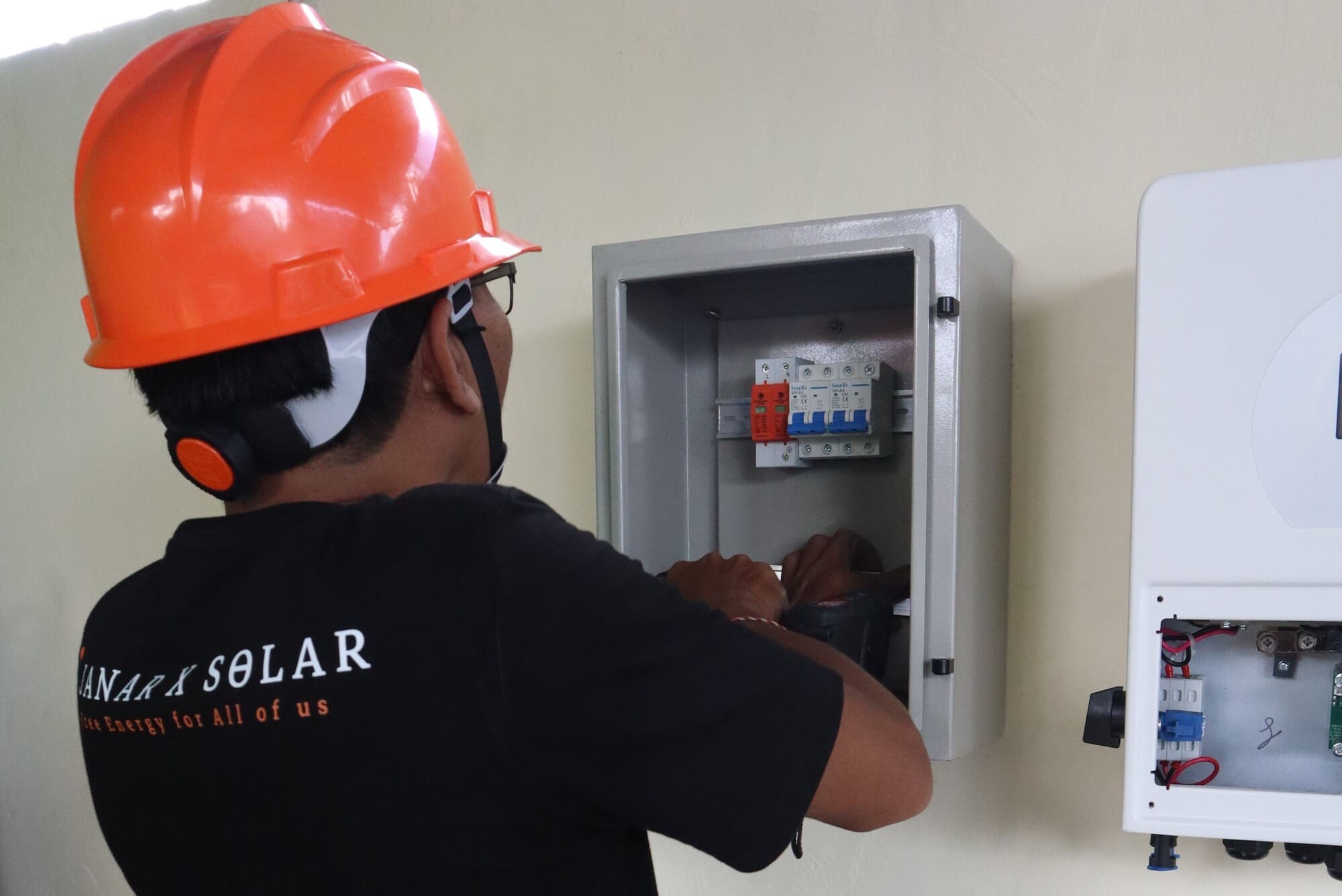 Technician working on a solar inverter box